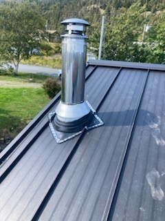 Black steel roof with chimney installed by Freedom Metal Roofing NL
