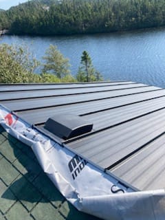 Black steel roof with roof vent installed by Freedom Metal Roofing NL
