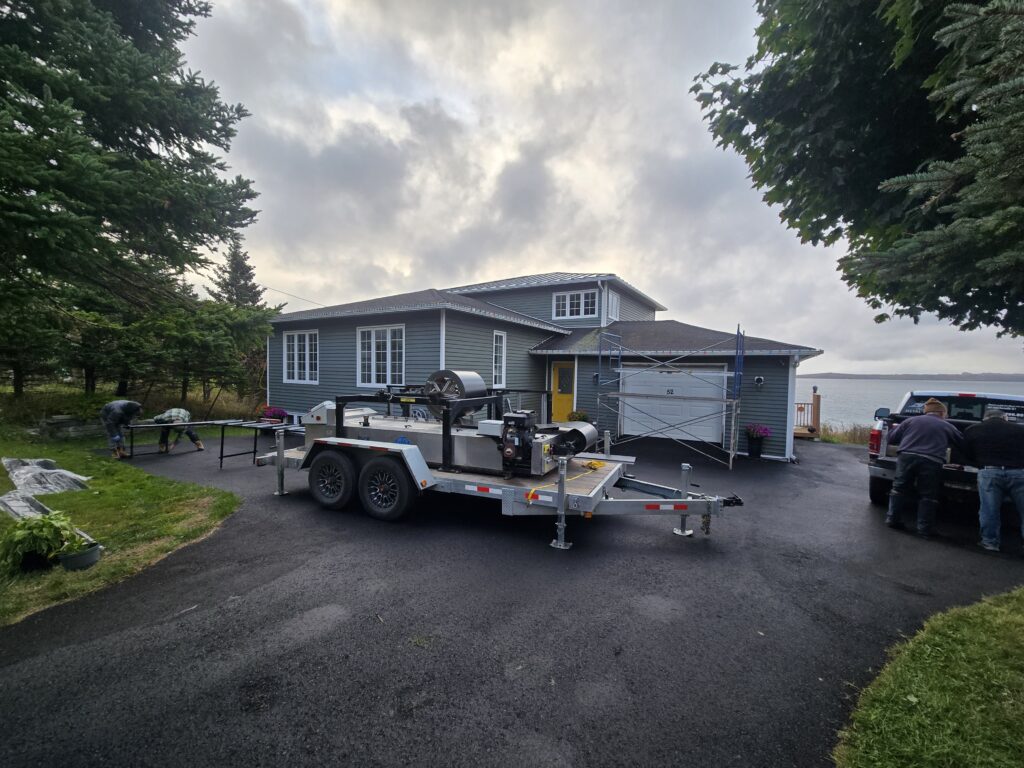 Mobile metal roofing panel machine set up at a job site by Freedom Metal Roofing NL
