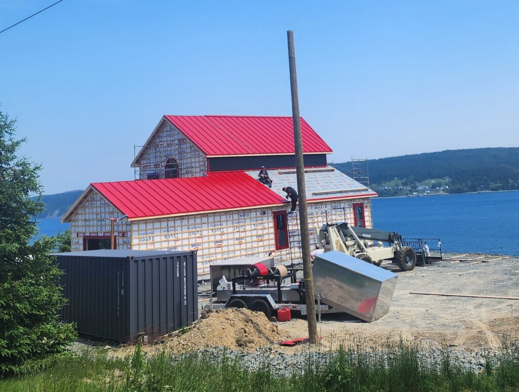 Steel roofing panels being fabricated on-site with Freedom Metal Roofing mobile unit in NL